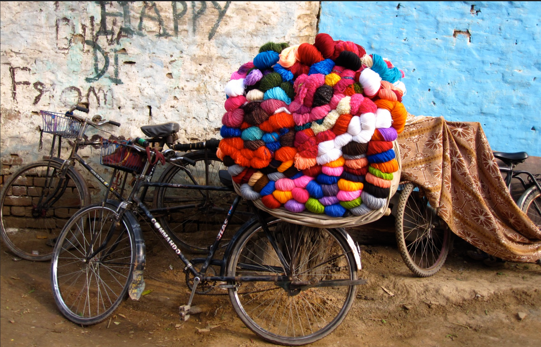A bicycle loaded with a towering mountain of colourful yarn balls